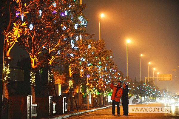 27日晚,在漢口沿江大道,兩位市民在景觀燈下合影。